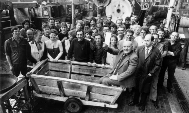 Jim Armstrong officially retired in 1984 after nearly 51 years with textile manufacturers Crombie at Grandholm Works in Aberdeen, he is pictured surrounded by colleagues. Image: DC Thomson