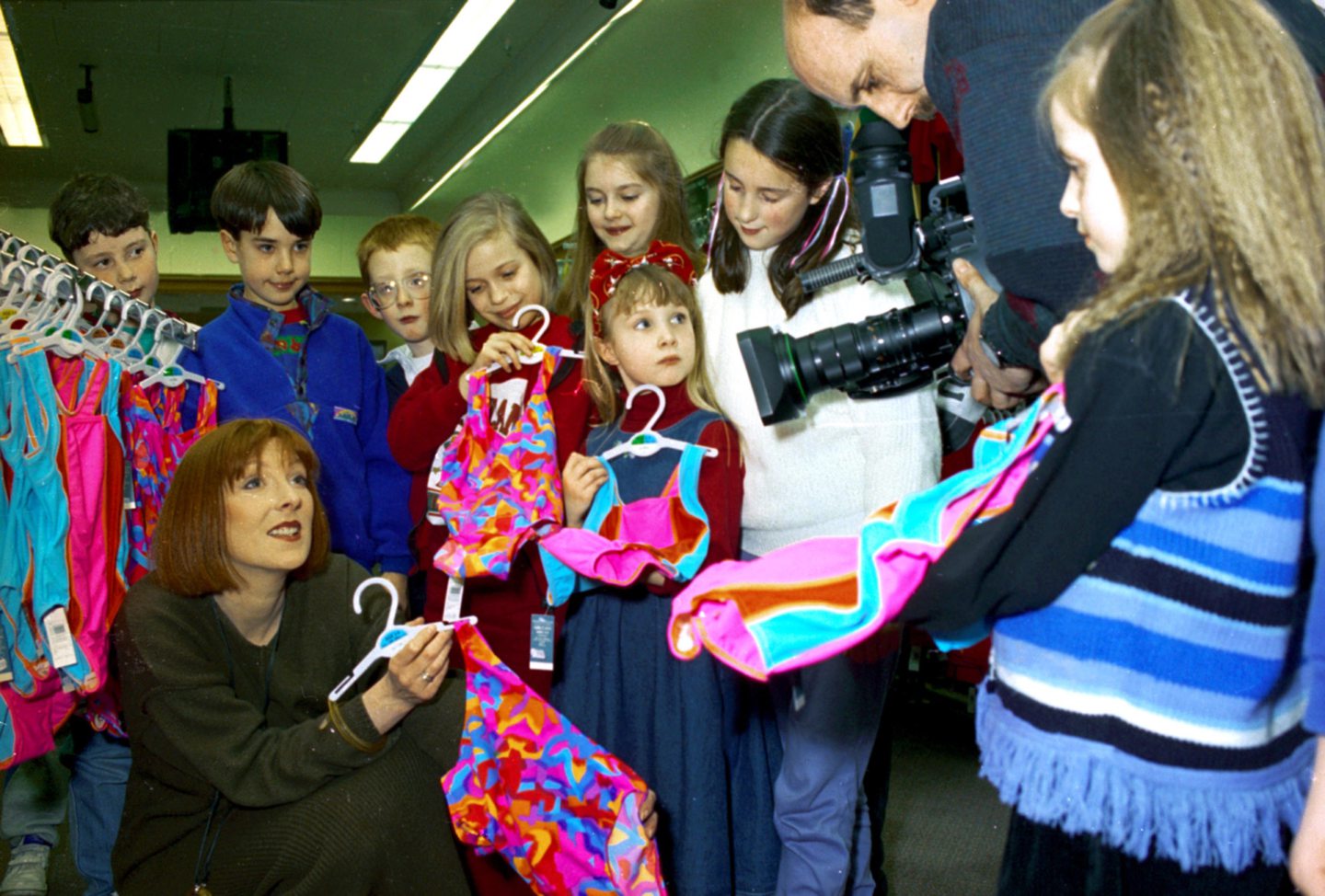 Port Elphinstone Primary School pupils and an adult woman holding brightly coloured swimsuits