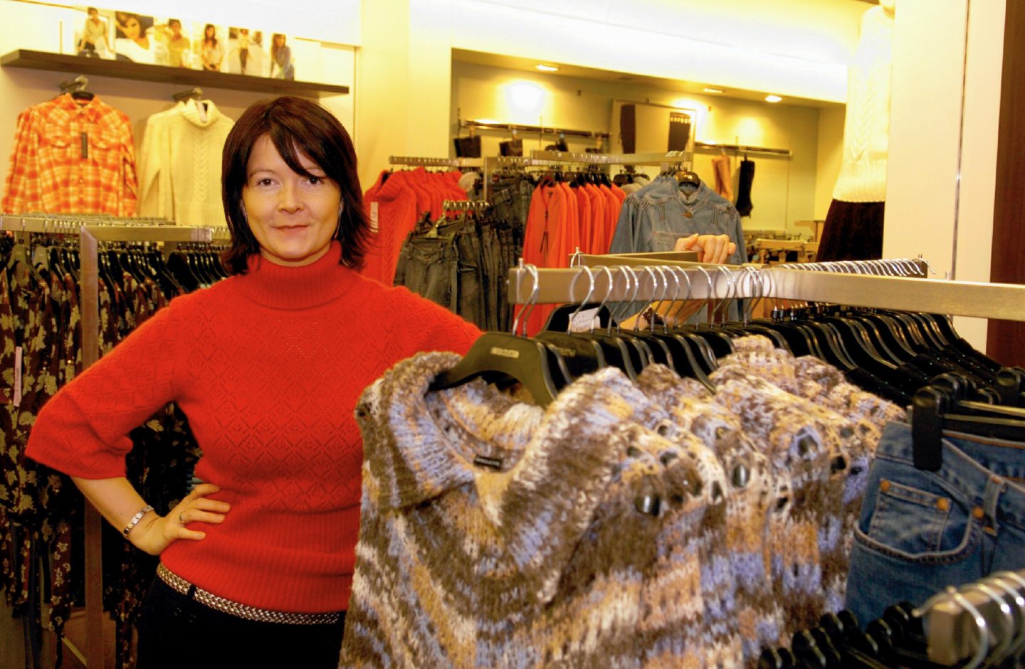 A woman standing among the clothing rails