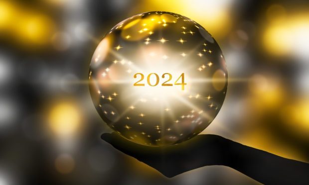Fortunetelling 2024 with a golden crystal ball in a hand.