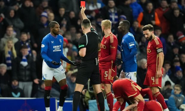 Referee Don Robertson shows a straight red card to Dujon Sterling of Rangers for a challenge on Jack MacKenzie of Aberdeen. Image: Shutterstock.