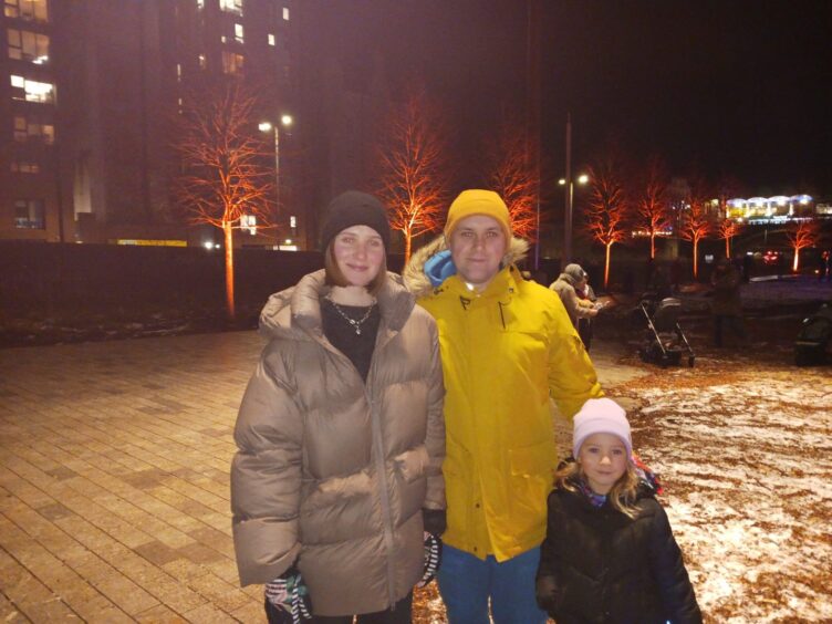 Ilona Krokhina standing with husband and daughter.