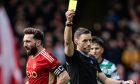 Aberdeen's Graeme Shinnie is shown a yellow card by the referee during a match with Celtic.