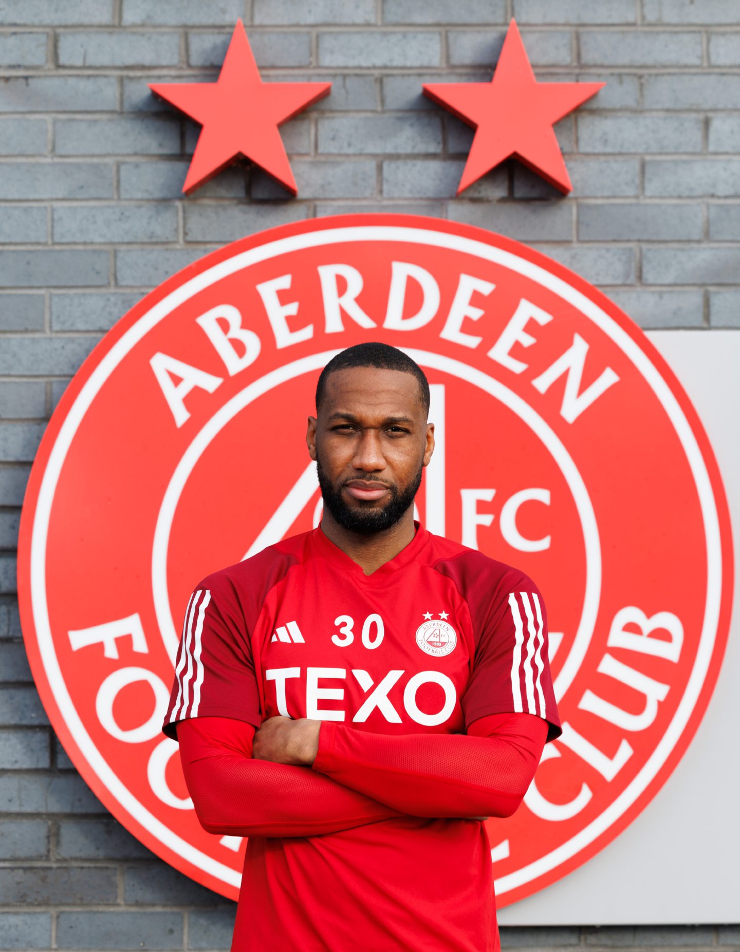 Hoilett in front of an AFC sign at pittodrie