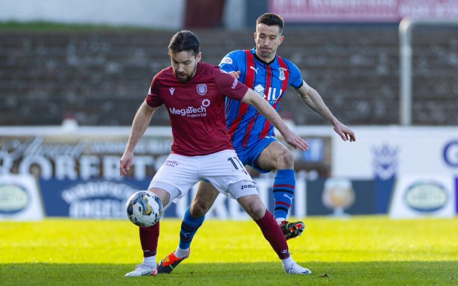 Cammy Kerr of Caley Thistle battles with Arbroath's Ryan Dow in the Championship match at Gayfield.