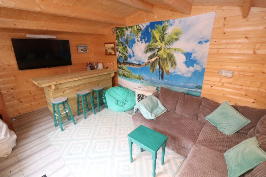 Inside the summer house, which has another bar, a sofa and a wall-mounted TV