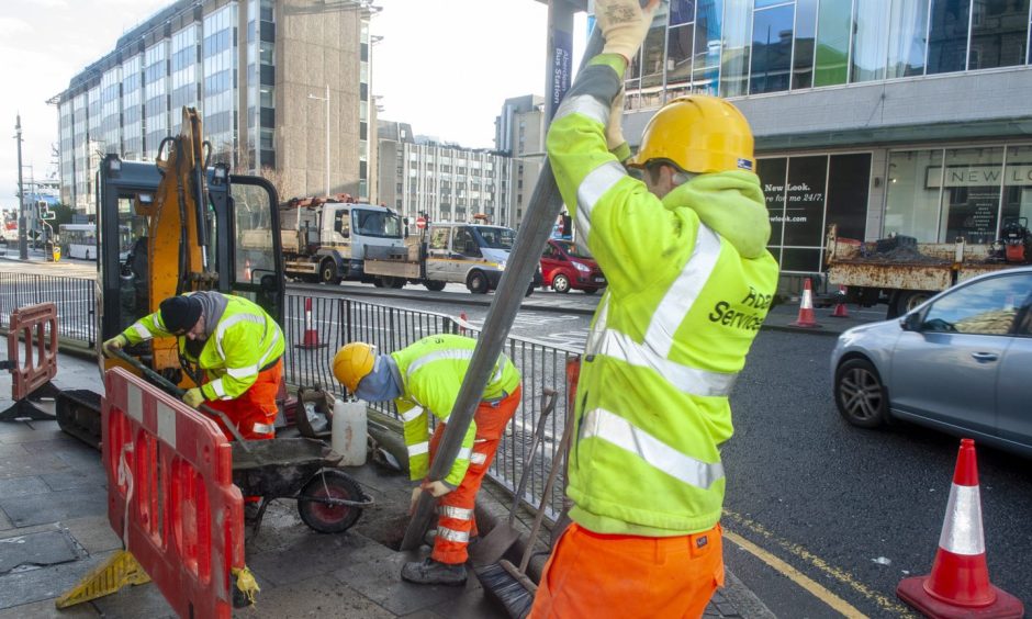 Council workers installing pole for LEZ sign in Aberdeen.