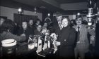 1977: A very 1970s scene at the newly-refurbished St Clements Bar in Aberdeen. Dons striker Joe Harper poured a pint to officially reopen St Clements Bar on St Clement Street, which had been closed for modernisation. Behind Joe are joint owners Bryan McHugh (left) and Mr Norman Stafford. Image: DC Thomson