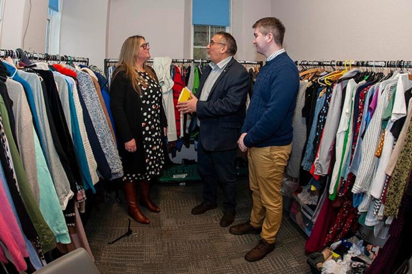 Jennifer McAughtrie of Aberdeen Cyrenians shows Christian Allard and Desmond Bouse rails of donated clothes