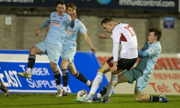 Aaron Reid, centre, of Aberdeen has a shot against Keith. Pictures by Jasperimage.