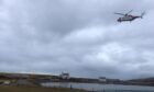 Helicopter flying over Stromness.