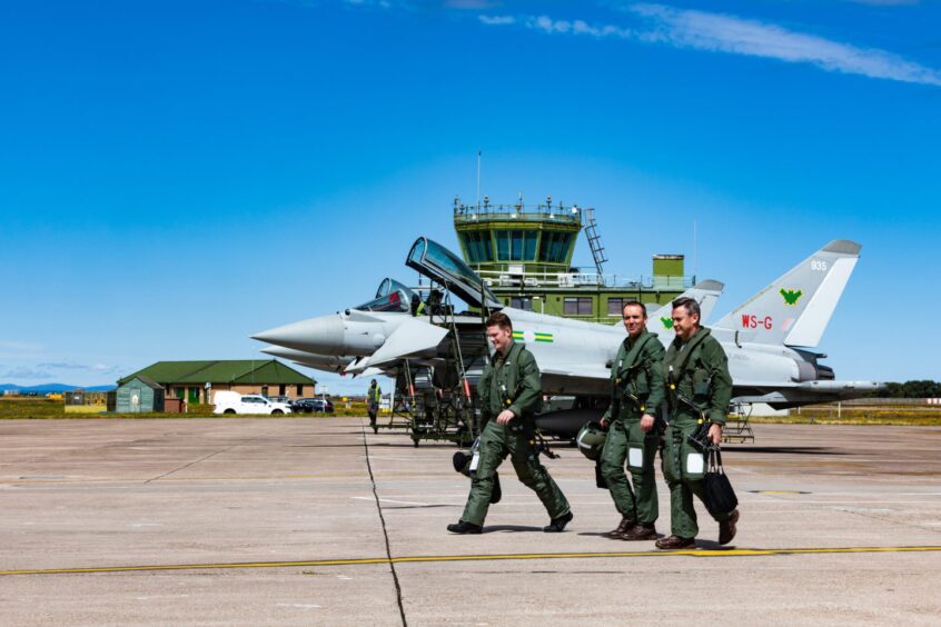 Pilots on runway in front of jet