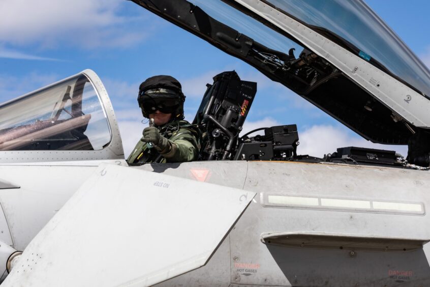 Jet fighter pilot giving thumbs up for take-off.