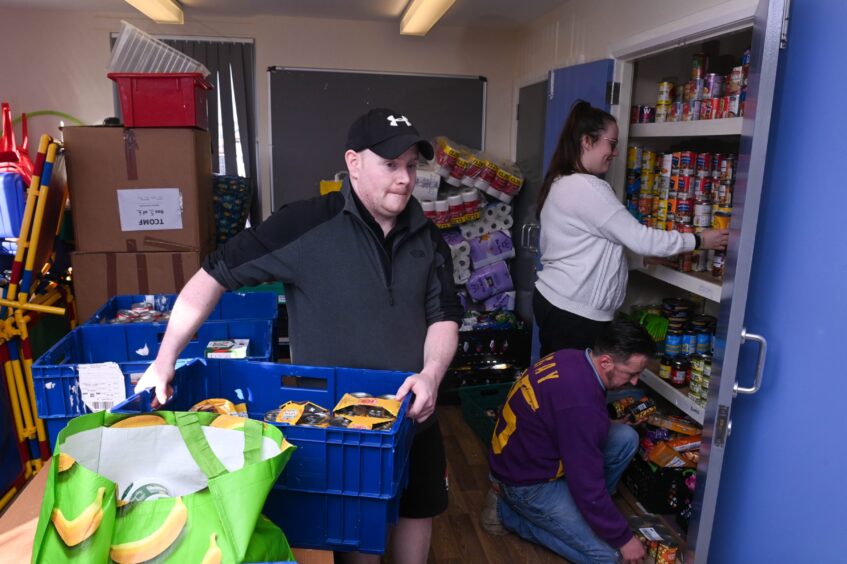 Volunteers stocking shelves at Tilly Community Flat foodbank in Aberdeen.