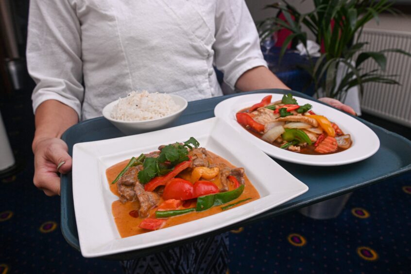 The two main dishes being carried on a tray. 