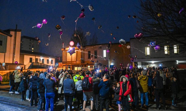 Balloons being released with crowds gathered.