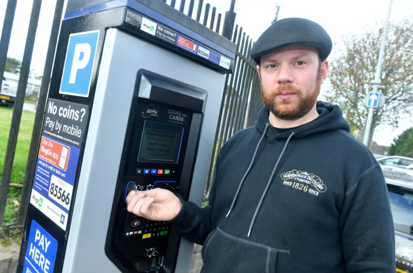 Inverurie whisky shop owner Mike Stewart at a parking pay station.