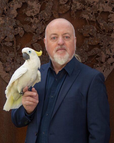 Bill Bailey holding a Cockatoo.