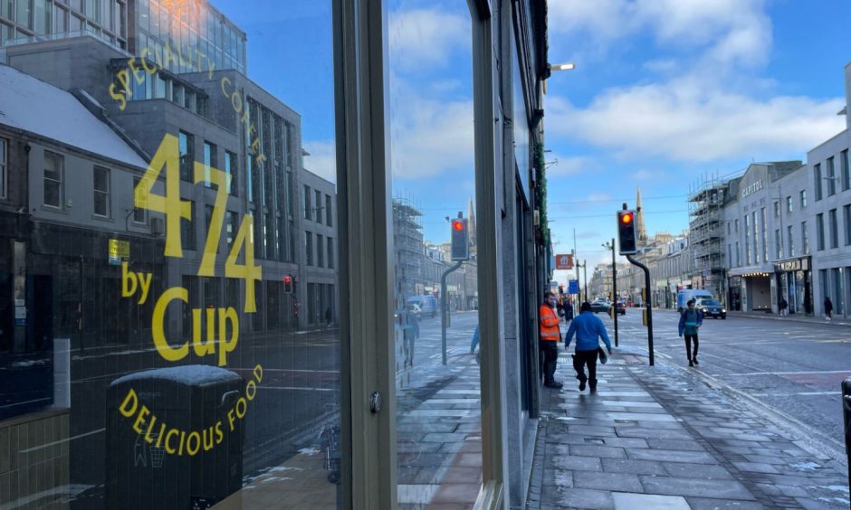 Cup posters on windows of new shop at the top of Union Street.