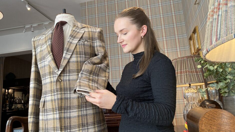 Buckie textile design student Lois Cowie stands with her jacket inside the Huntsmanstore on Savile Row.