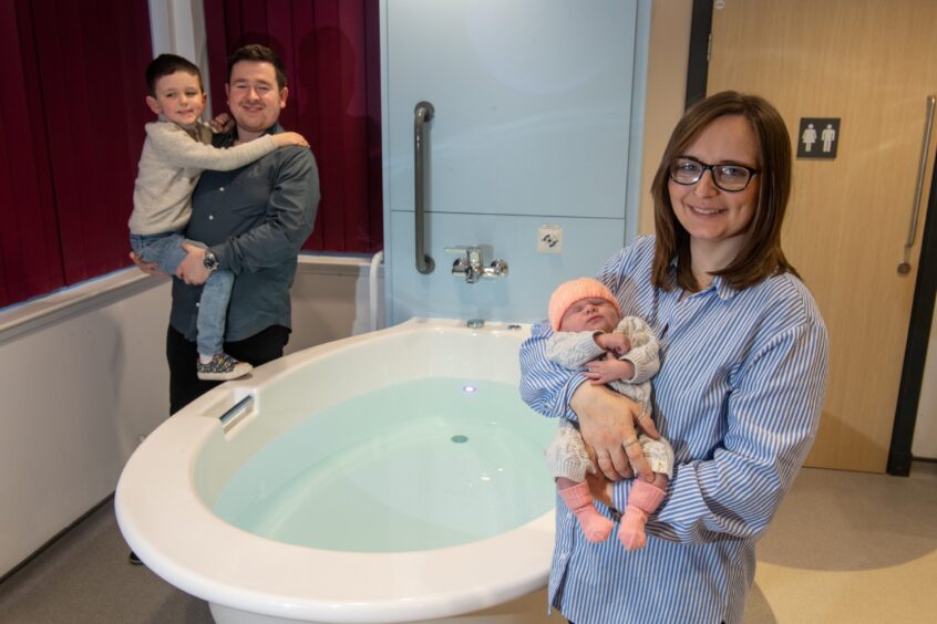 Natalie stands with her family next to a filled up birthing pool in Inverurie