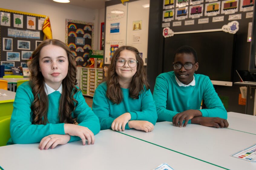Three Greyhope School P7 pupils sitting at a classroom table
