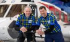 Michael Fotheringham and John Fyall stand in front of a Bristow helicopter at Aberdeen Airport