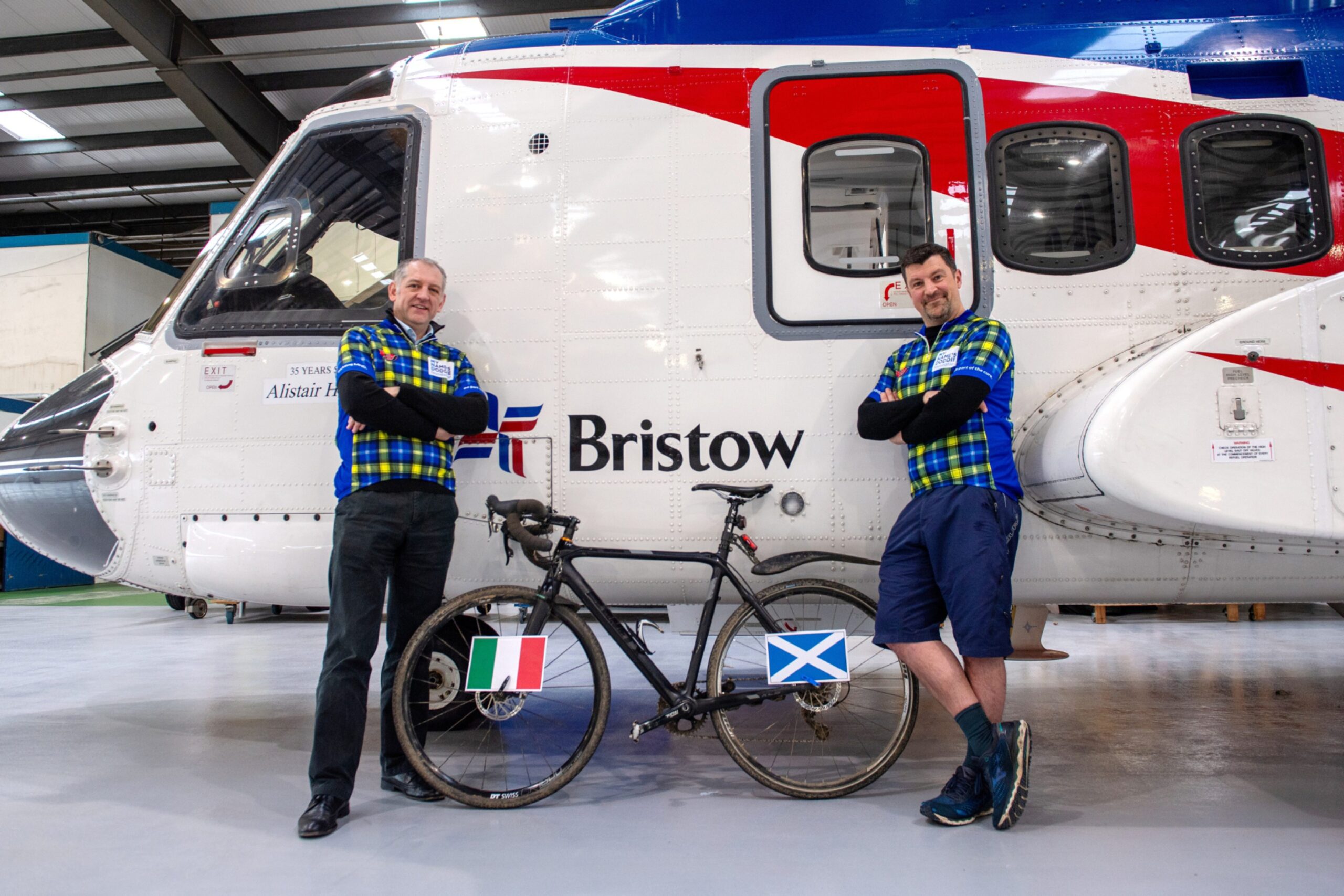 Michael and John with a bike displaying Italy and Scotland flags.