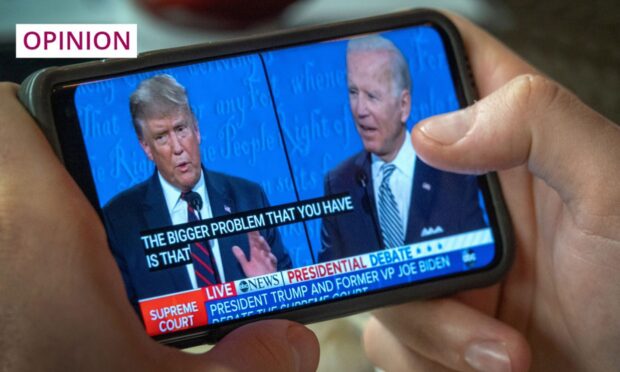 A man watches the 2020 presidential debate on his mobile phone. Donald Trump and Joe Biden are expected to go head-to-head once again in 2024. Image: Cristobal Herrera-Ulashkevich/EPA-EFE/Shutterstock