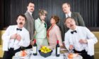 The cast of Faulty Towers interactive dining experience posing around the table.