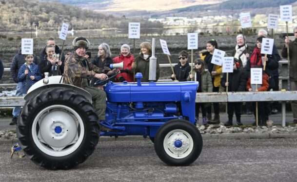 A protester drives by in a tractor as part of protests against the potential creation of a Lochaber National Park. Image: Iain Ferguson