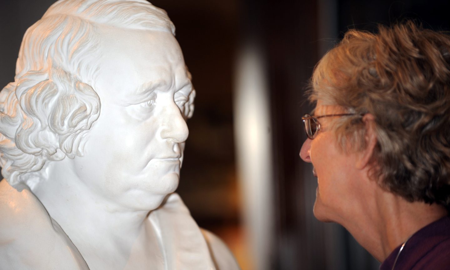 Woman face-to-face with bust of Hugh Falconer.