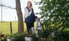 Maria Hall at roadside tribute to Fabian with photograph and flowers.