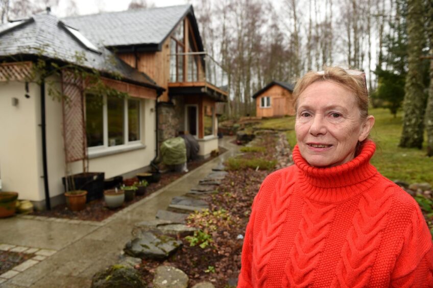 Stephanie Bunyan, dressed in a red jumper, in the back garden of her home in Insh.