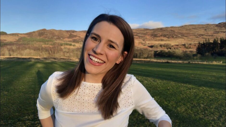 Sophie Stephenson smiling at the camera, highland countryside behind her