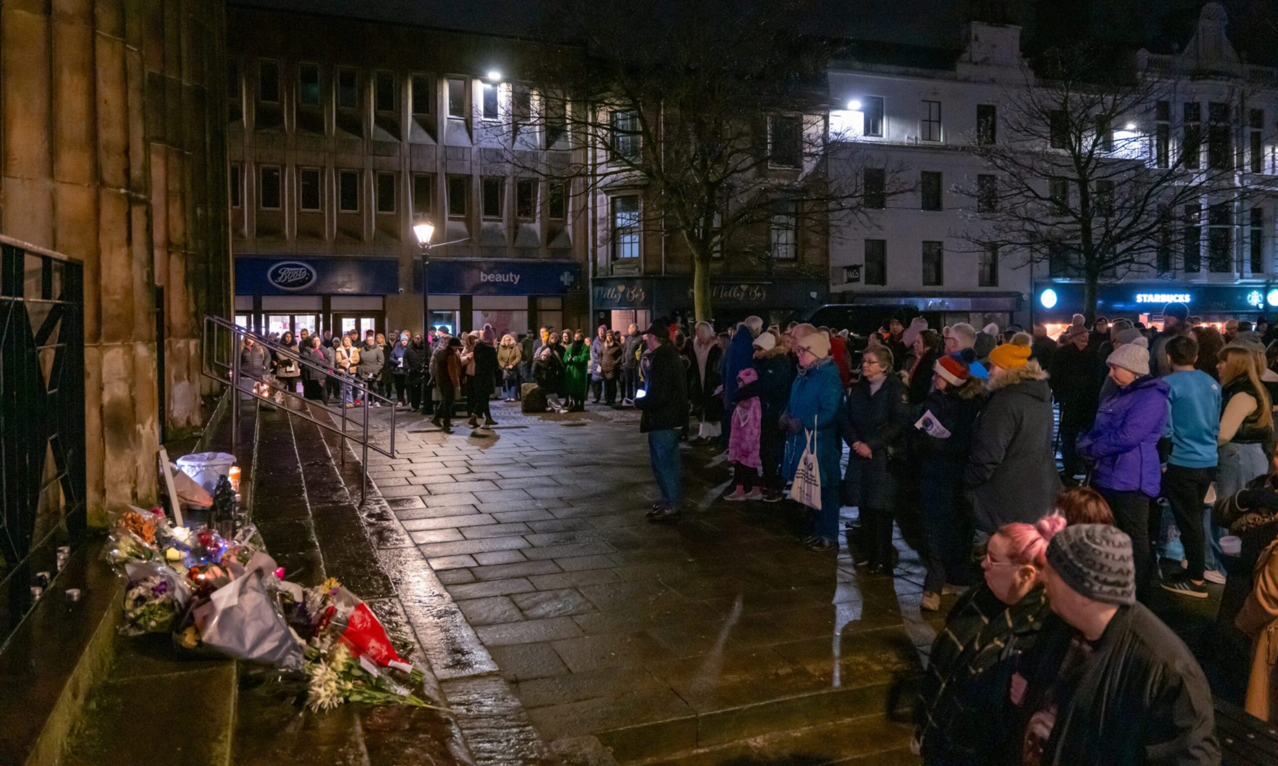Candlelight vigil with crowds around church on Elgin High Street. 