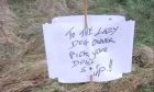 A sweary sign appeared on the side of the road, along with grapes and raisins which are toxic to dogs. Image: Supplied