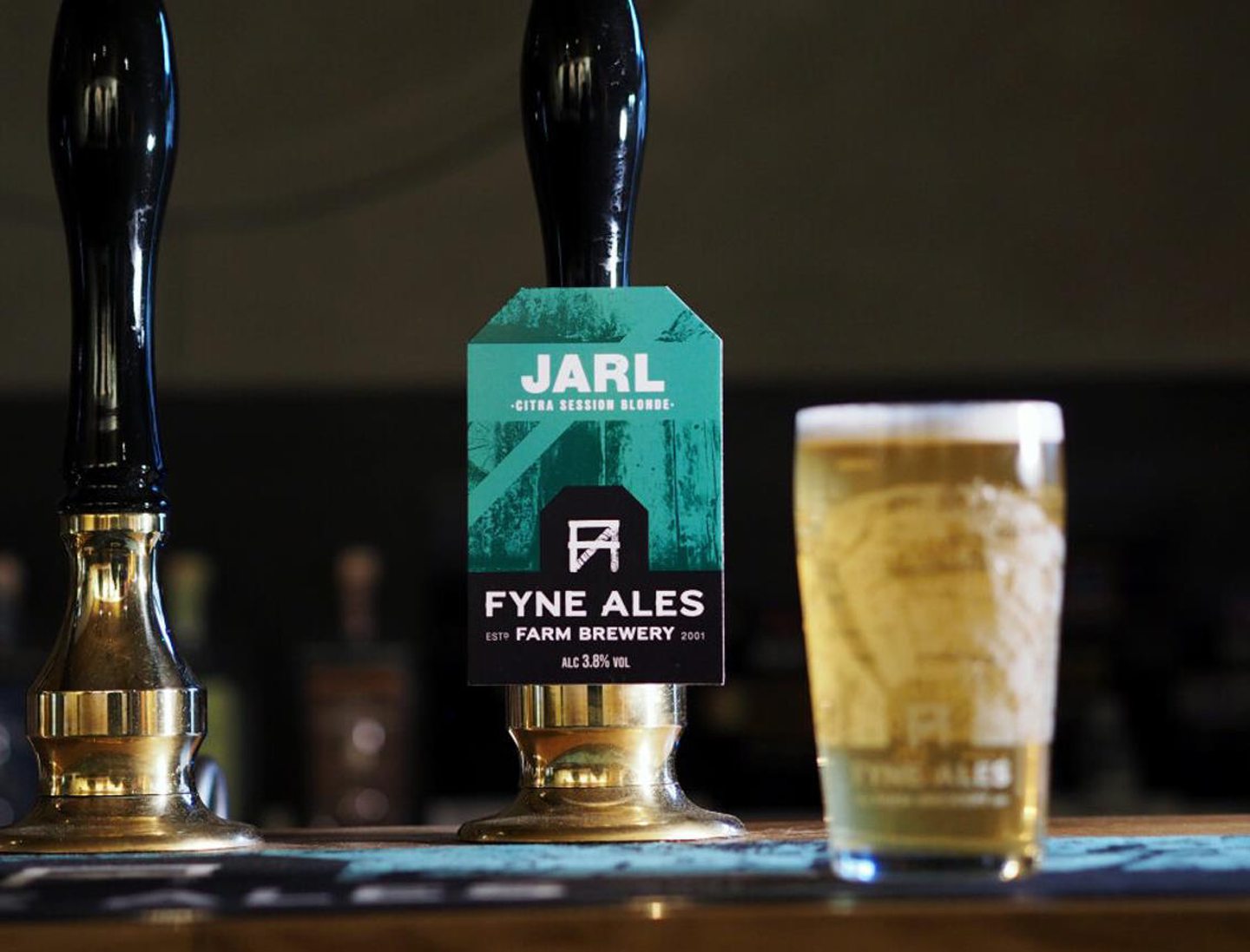 A pint of Jarl next to a beer tap.