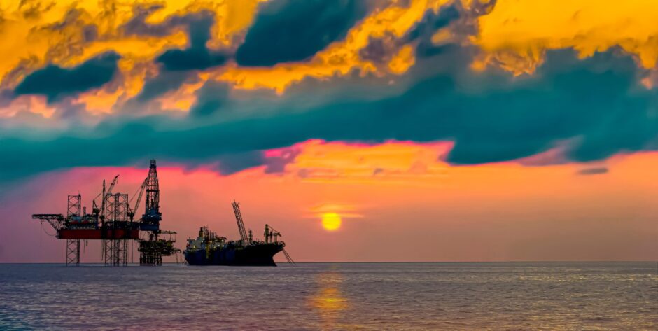 Drilling rig and FPSO ship silhouette view with sunset golden hours sky 