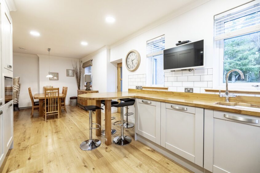 The kitchen inside the house for sale near Crathes Castle, featuring breakfast bar and solid wood units.