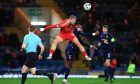 Aberdeen midfielder Killian Phillips competes in the air with Mohamad Sylla of Dundee; Dens Park, Image: Shutterstock.