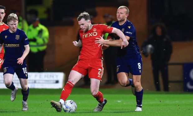 Aberdeen defender Nicky Devlin challenges for the ball with Curtis Main of Dundee. Image: Shutterstock