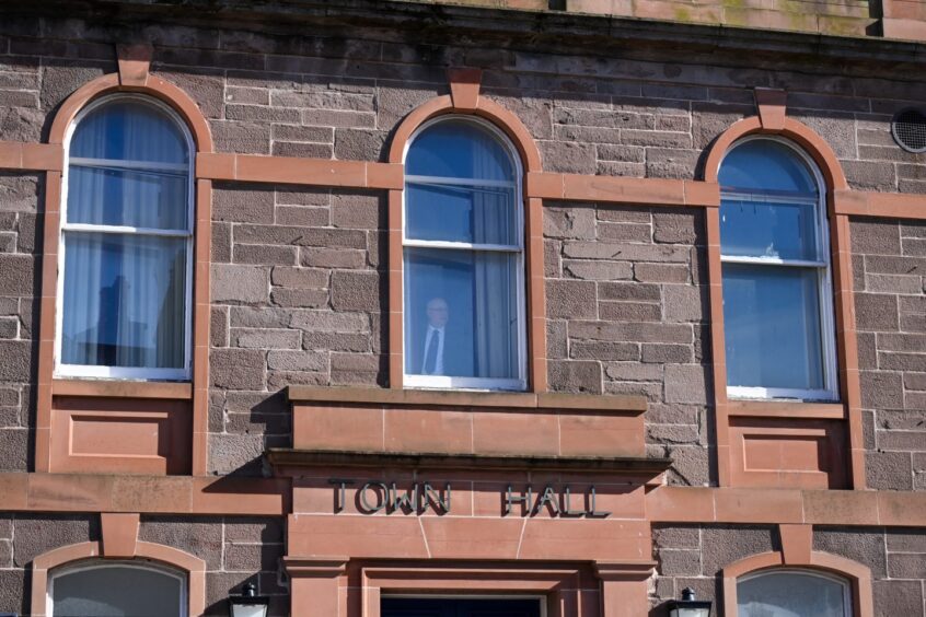 Man looking out window of Stonehaven Town Hall