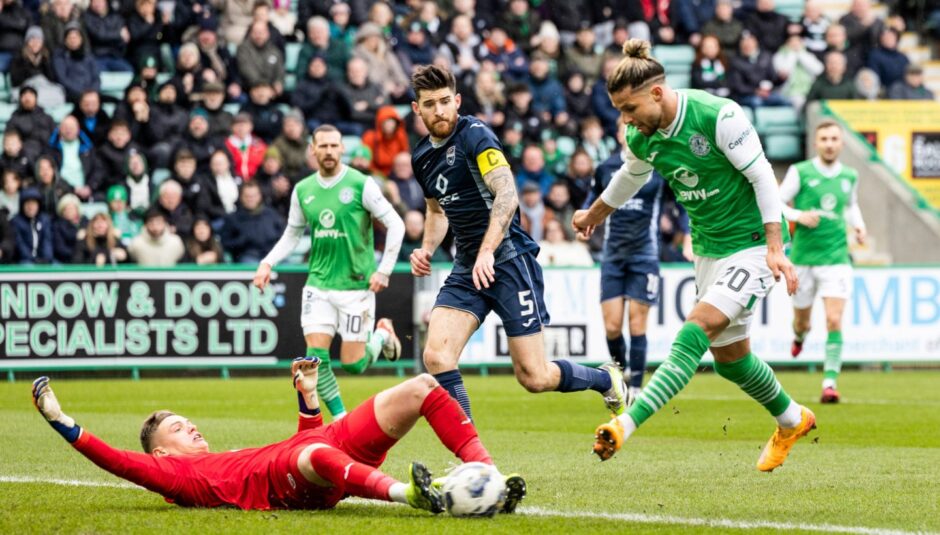 Ross County's George Wickens saves a shot from Hibernian's Emiliano Marcondes.
