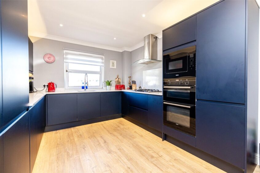 Stylish kitchen in the Aberdeen home, featuring navy blue cabinets and quartz worktop.