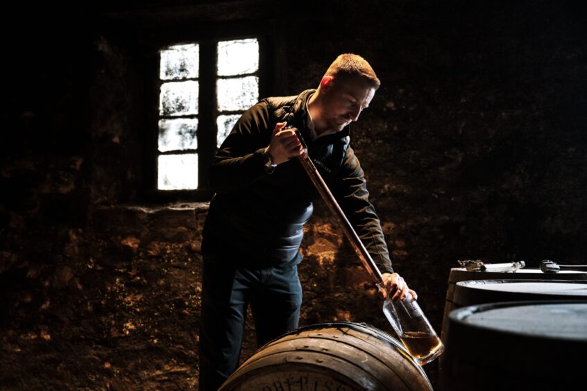 Port Ellen master distiller Ali McDonald draws whisky from the cask. 