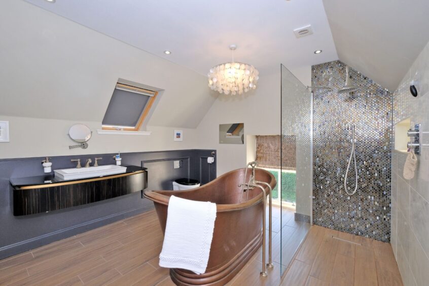 Spacious bathroom with shower and freestanding bath inside the Aberdeenshire steading conversion