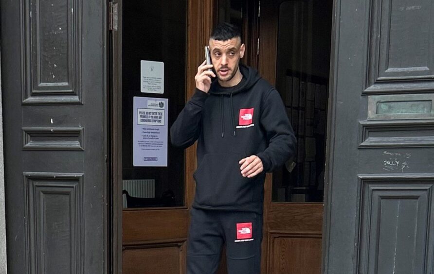 Daniel Smith walking out of Aberdeen Sheriff Court on the phone