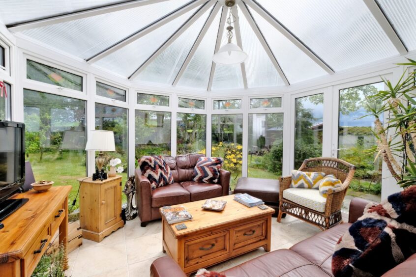 The conservatory with leather and wooden furniture