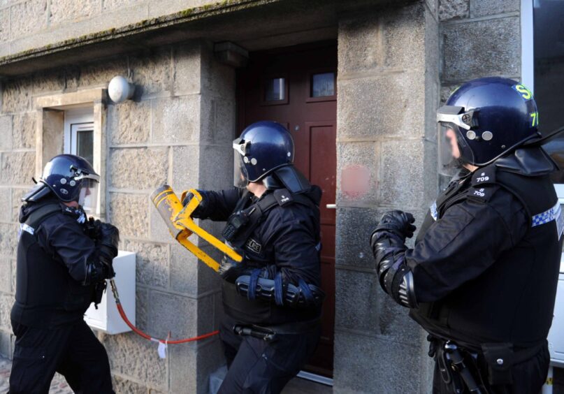 Police break down a door in Fraserburgh during drug raid in 2018. 